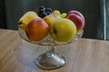 A group of different fresh ripe fruits - apple, peach, grapes and pears in a fruit bowl