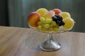 A group of different fresh ripe fruits - apple, peach, grapes and pears in a fruit bowl