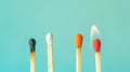 Group of different matches, some burning, pastel blue background, leadership, idea generation, teamwork. Generative AI Royalty Free Stock Photo