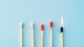 Group of different matches, some burning, pastel blue background, leadership, idea generation, teamwork. Generative AI Royalty Free Stock Photo