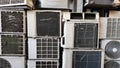 A group of dirty, dusty and broken air conditioning compressors are stacked in a landfill. a lot of old air conditioners and on