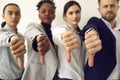 Group of diverse business people giving thumbs down showing dislike of bad work results