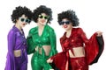A group of disco girls in African American wigs and colorful costumes Royalty Free Stock Photo