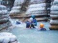 A group of divers in wetsuits rafting down the river surrounded by canyons in the gorge. Canyoning. Leisure. Selective Royalty Free Stock Photo