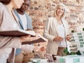 Group of diverse architects discussing plans, blueprints and schematics during a meeting in their office boardroom Royalty Free Stock Photo