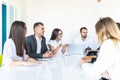 Group of diverse business executives holding a meeting around a table discussing graphs showing statistical analysis. Team work Royalty Free Stock Photo