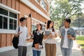 Group of diverse cheerful Asian students friends are enjoying talking while walking in their campus Royalty Free Stock Photo