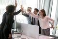 Group of diverse coworkers giving high five share common success