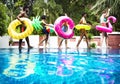 Group of diverse friends enjoying summer time by the pool with i Royalty Free Stock Photo