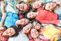 Group of diverse friends having fun outdoor - Happy young people lying on grass after picnic and laughing together Royalty Free Stock Photo