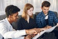 Group of diverse friends looking at map in the bright room