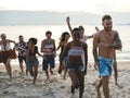 Group of diverse friends running at the beach together