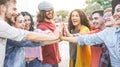 Group of diverse friends stacking hands outdoor - Happy young people having fun joining and celebrating together