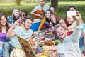 Group of diverse friends taking photo selfie while doing picnic in park - Happy young people having with new mobile phone Royalty Free Stock Photo