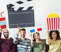 Group of diverse friends watching movie together holding icons Royalty Free Stock Photo