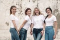 Group of diverse girls in tshirts and jeans over street wall Royalty Free Stock Photo