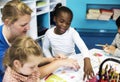 Group of diverse Kids coloring workbook in class