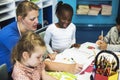 Group of diverse Kids coloring workbook in class