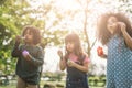 Group of Diverse Kids cute friends having bubble fun on green lawn in park. Royalty Free Stock Photo