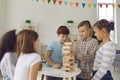 Group of diverse kids playing wood block tower building game at home or in leisure club