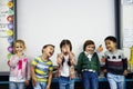 Group of diverse kindergarten students standing together in classroom Royalty Free Stock Photo