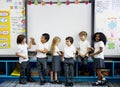 Group of diverse kindergarten students standing together in classroom Royalty Free Stock Photo