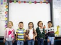 Group of diverse kindergarten students standing together in classroom Royalty Free Stock Photo