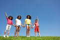 Group of kids stand holding hand over clean sky Royalty Free Stock Photo