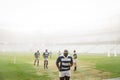 Group of diverse male rugby players running in stadium