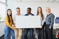 Group of diverse multi ethnic business people holding white blank banner in office Royalty Free Stock Photo