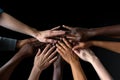 Group of diverse people putting hands together on black background, closeup, Team members high-fiving close-up, Hands visible only