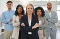 Group of diverse and powerful businesspeople standing together with their arms folded in an office. Confident and mature Royalty Free Stock Photo