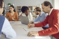 Group of diverse business people discussing their projects sitting at office table together Royalty Free Stock Photo