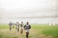 Group of diverse rugby players running together in stadium