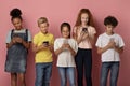 Group of diverse schoolkids stuck in mobile phones studying online on pink background