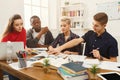 Group of diverse students studying at wooden table Royalty Free Stock Photo