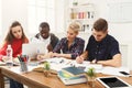 Group of diverse students studying at wooden table Royalty Free Stock Photo