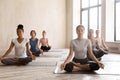 Group of young women practicing yoga, Ardha Padmasana exercise