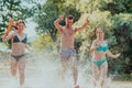A group of diverse young people having fun together as they run along the river and play water games Royalty Free Stock Photo