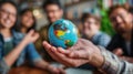 A group of diverse young people holding a globe in their hands, representing the interconnectedness of the world and the Royalty Free Stock Photo