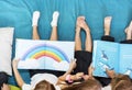 Group of Diverse Young Students Reading Children Story Book Together