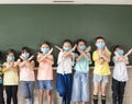Group of diverse young students wear mask and showing stop sign gesture in classroom Royalty Free Stock Photo