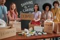 Group of diverse young volunteers smiling at camera while packing pills, medicine donation, Girls holding card with Royalty Free Stock Photo