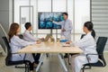 Group of doctor in white gown, discussing brain scans on large monitor in a meeting room Royalty Free Stock Photo
