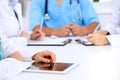 Group of doctors at medical meeting. Close up of physician using tablet computer. Royalty Free Stock Photo