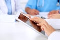 Group of doctors at medical meeting. Close up of physician using tablet computer. Royalty Free Stock Photo