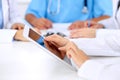 Group of doctors at medical meeting. Close up of physician using tablet computer. Royalty Free Stock Photo