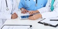 Group of doctors at medical meeting. Close up of physician using touch pad or tablet computer Royalty Free Stock Photo