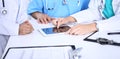 Group of doctors at medical meeting. Close up of physician using touch pad or tablet computer Royalty Free Stock Photo