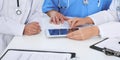 Group of doctors at medical meeting. Close up of physician using touch pad or tablet computer Royalty Free Stock Photo